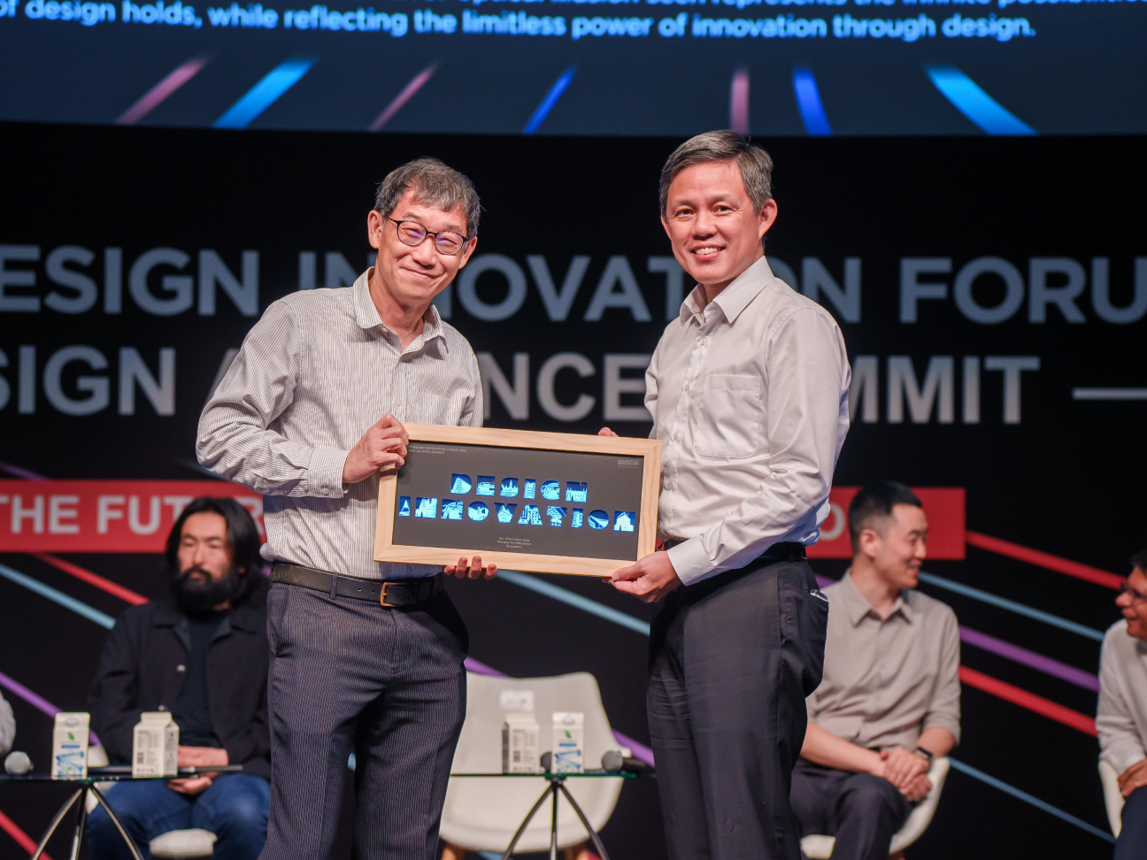 2 men holding a Design Innovation sign