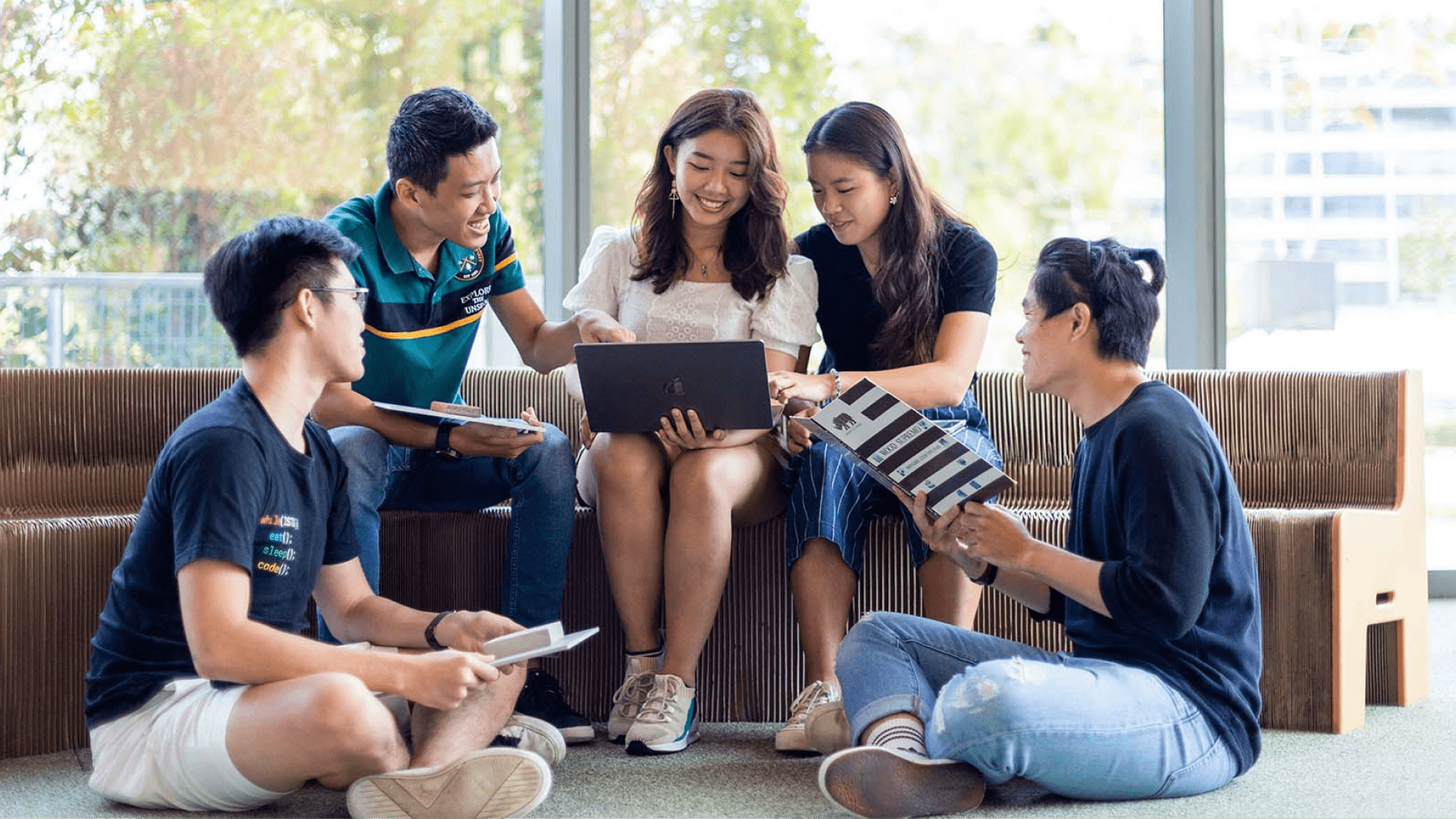 Students gathered around to discuss over a laptop